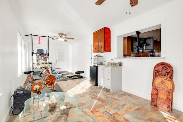 kitchen featuring ceiling fan, sink, and crown molding