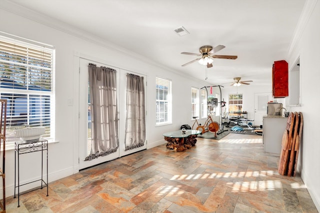 entryway with ceiling fan and crown molding