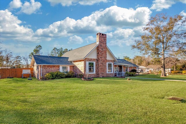 rear view of house featuring a yard