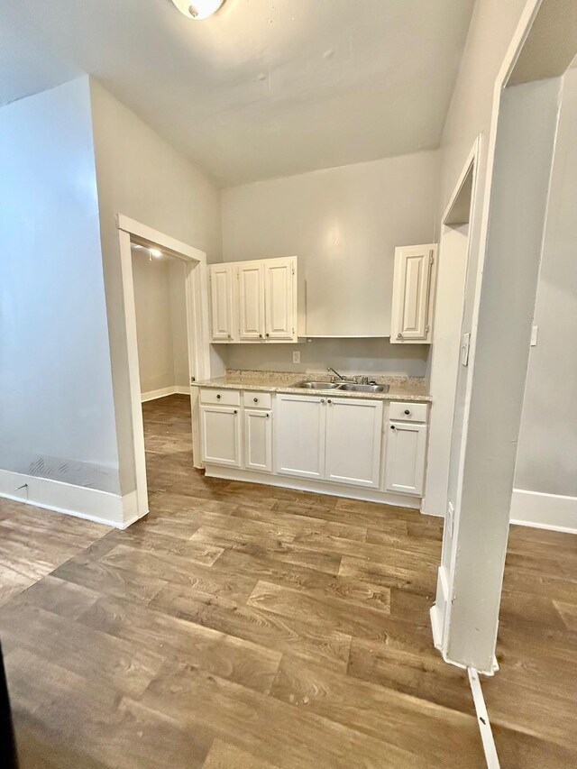 932 Dallas Ave, Port Arthur, TX 77640 - kitchen featuring baseboards, a sink, light wood-style floors, and white cabinets