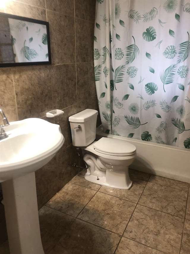 bathroom featuring shower / bathtub combination with curtain, tile walls, and toilet