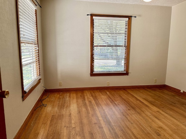 empty room featuring light hardwood / wood-style floors and a textured ceiling