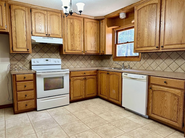 kitchen with light tile patterned floors, white appliances, an inviting chandelier, and sink