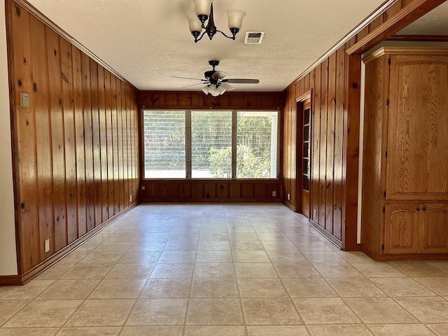 unfurnished sunroom with ceiling fan with notable chandelier