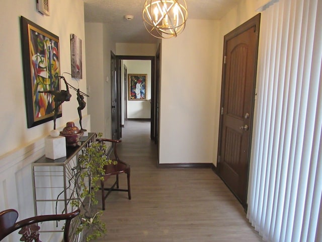 hall with hardwood / wood-style floors and a chandelier