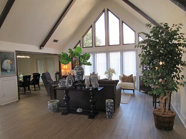 living room featuring hardwood / wood-style flooring, high vaulted ceiling, and beamed ceiling