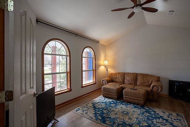 living room with ceiling fan, vaulted ceiling, and wood-type flooring