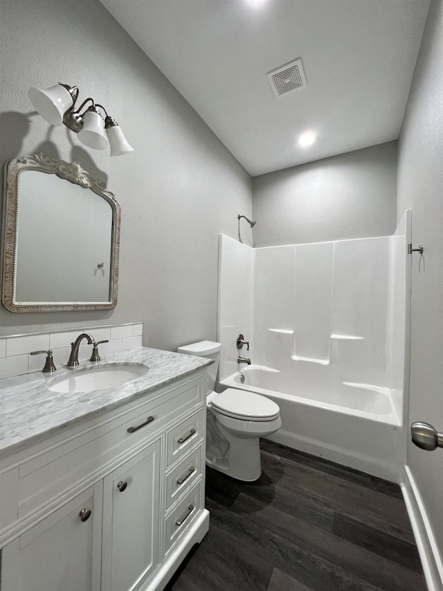 full bathroom featuring vanity, wood-type flooring, bathtub / shower combination, and toilet