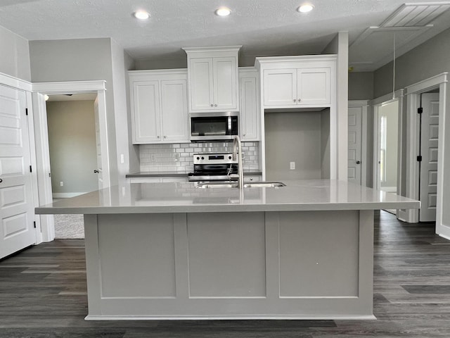 kitchen featuring a spacious island, sink, a textured ceiling, appliances with stainless steel finishes, and white cabinets