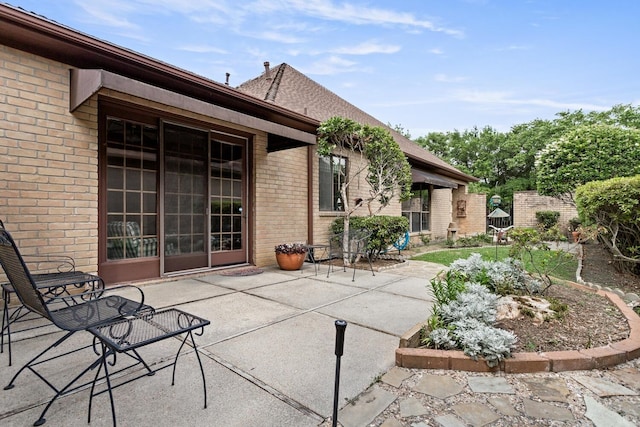 rear view of house featuring brick siding and a patio area