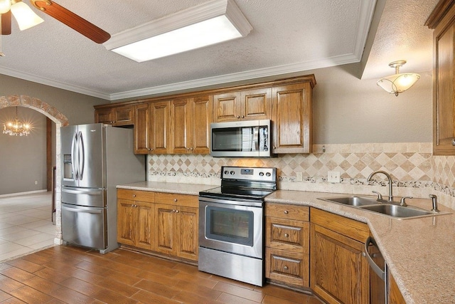 kitchen featuring crown molding, sink, a textured ceiling, and appliances with stainless steel finishes