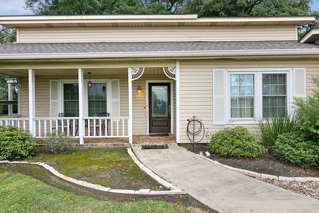 view of exterior entry featuring covered porch