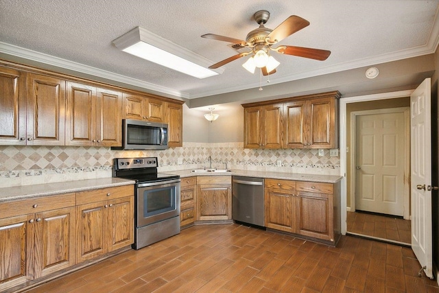 kitchen with decorative backsplash, ceiling fan, sink, and appliances with stainless steel finishes