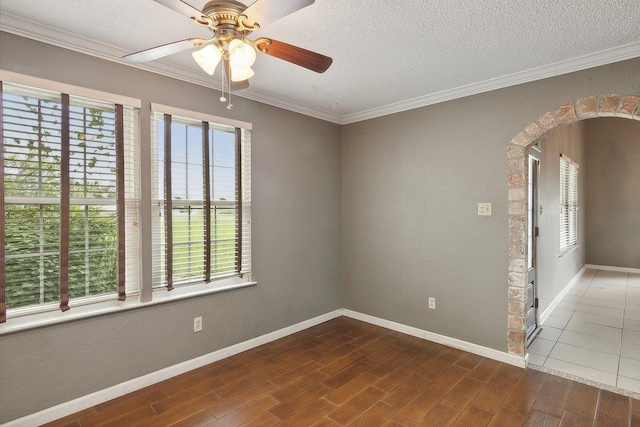 empty room with crown molding, ceiling fan, and a textured ceiling