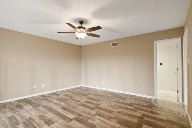 spare room featuring hardwood / wood-style floors, ceiling fan, and a textured ceiling