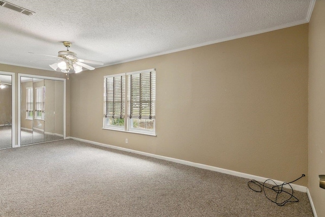 carpeted empty room with ceiling fan and a textured ceiling