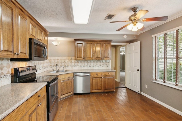 kitchen featuring ceiling fan, sink, stainless steel appliances, and tasteful backsplash