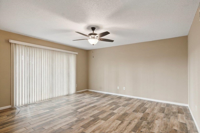 spare room featuring a textured ceiling, light hardwood / wood-style flooring, and ceiling fan