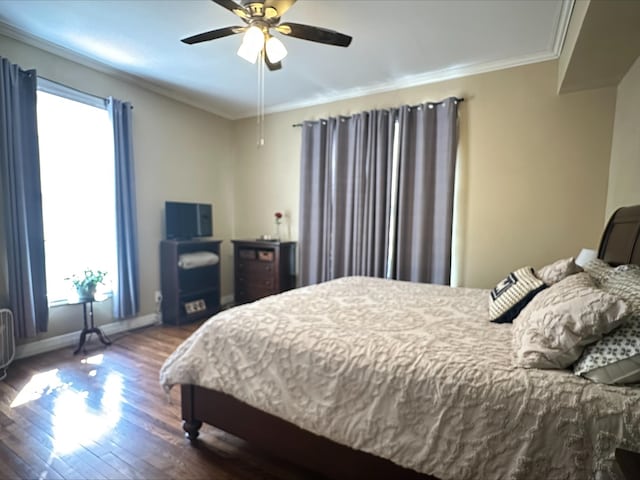 bedroom featuring ceiling fan, ornamental molding, and dark wood-type flooring