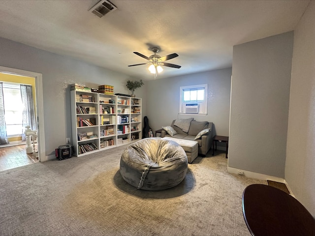 sitting room with ceiling fan and light colored carpet