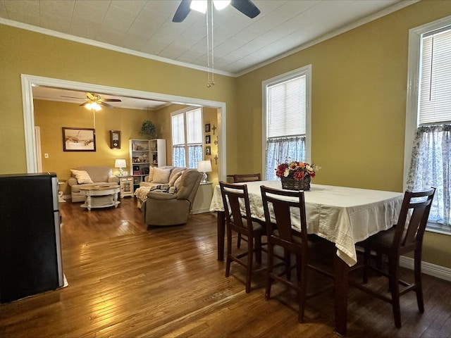 dining area featuring a healthy amount of sunlight, crown molding, and dark wood-type flooring