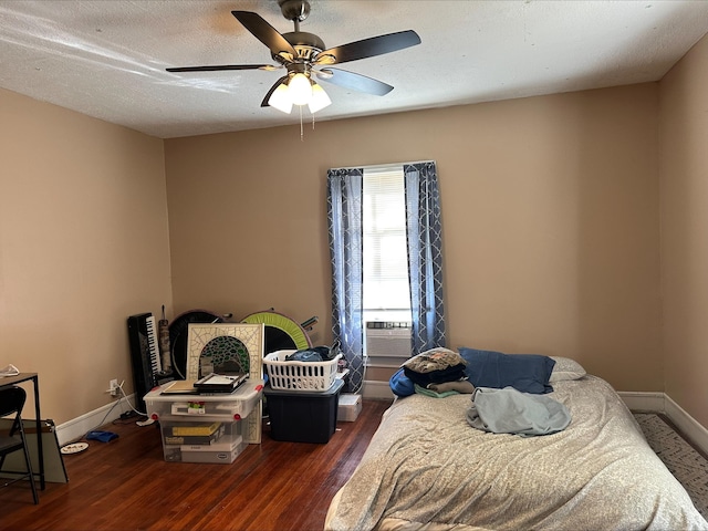 bedroom featuring ceiling fan, dark hardwood / wood-style floors, a textured ceiling, and cooling unit