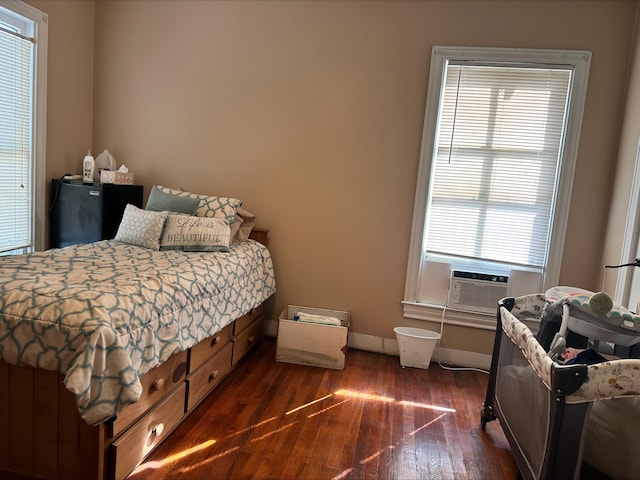 bedroom with multiple windows, cooling unit, and dark wood-type flooring