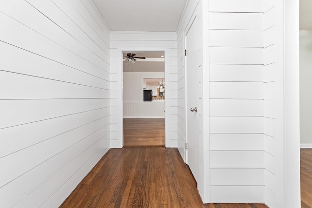 hallway featuring dark hardwood / wood-style floors and wooden walls