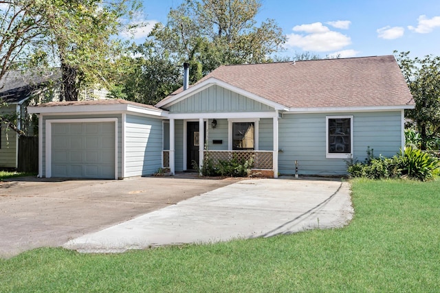 view of front of property featuring a front yard, a porch, and a garage