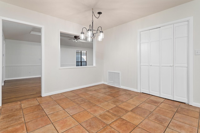 unfurnished dining area with ceiling fan with notable chandelier and light tile patterned floors