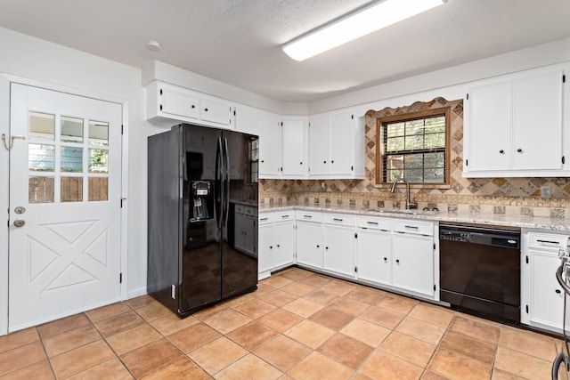 kitchen with black appliances, white cabinets, sink, tasteful backsplash, and light stone counters