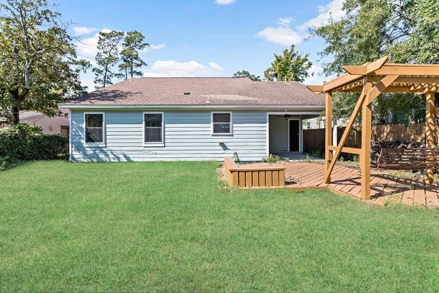 back of house featuring a pergola, a wooden deck, and a lawn