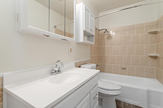 full bathroom with toilet, vanity, a textured ceiling, and tiled shower / bath