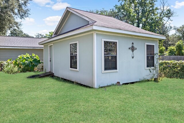 view of side of property featuring a yard and an outbuilding