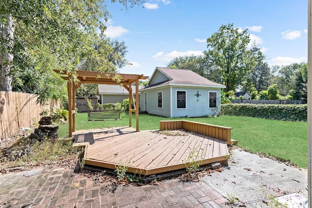 deck featuring a lawn, an outbuilding, and a pergola