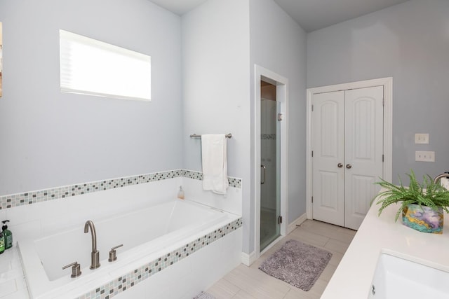 bathroom with a stall shower and a garden tub