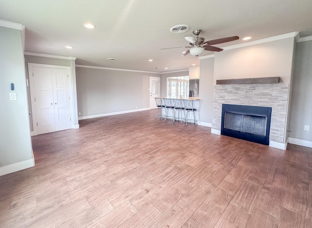 unfurnished living room with light wood-type flooring, baseboards, a fireplace, and visible vents