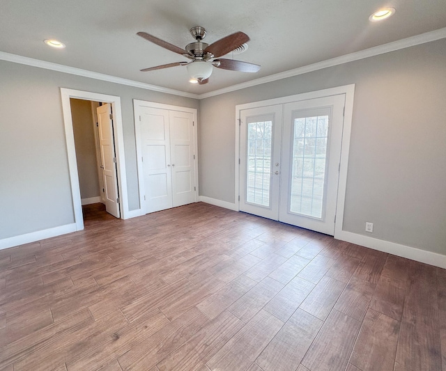 unfurnished bedroom with french doors, wood finished floors, and crown molding