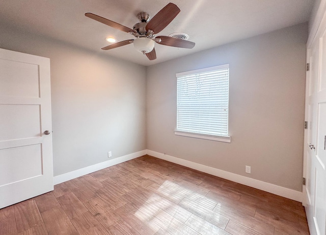 unfurnished room with wood finished floors, a ceiling fan, and baseboards