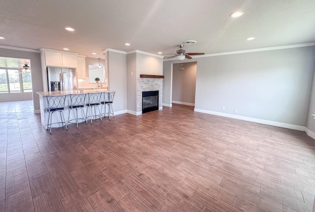 unfurnished living room featuring baseboards, a ceiling fan, and wood finished floors