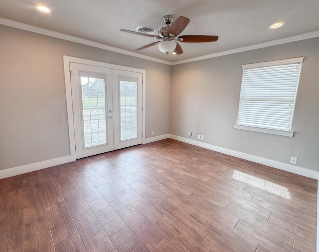 spare room featuring ornamental molding, french doors, visible vents, and wood finished floors