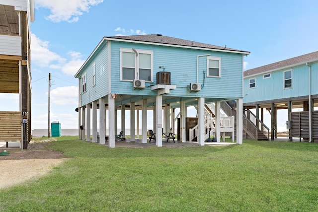 back of house with a patio area, stairway, a carport, and a yard