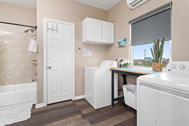 washroom with a wall unit AC, washing machine and dryer, baseboards, cabinet space, and dark wood-style floors