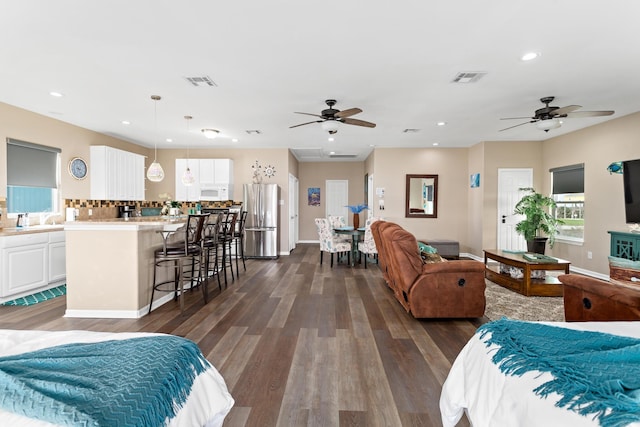 bedroom with recessed lighting, visible vents, dark wood finished floors, and freestanding refrigerator