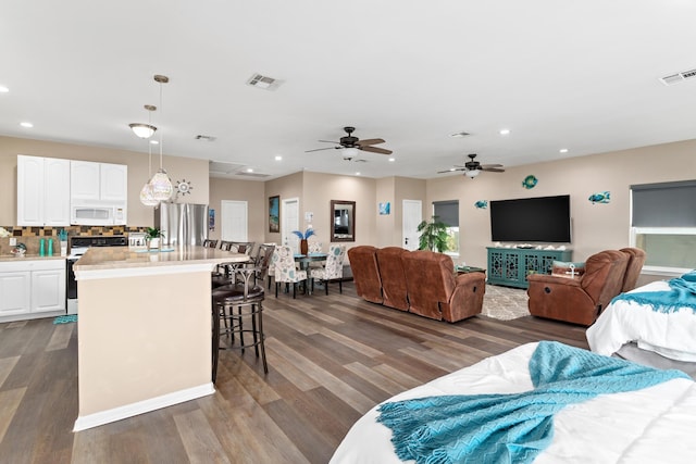 living room featuring visible vents, dark wood-style flooring, and recessed lighting