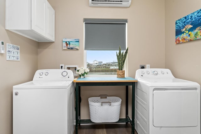 washroom with a wall unit AC, cabinet space, separate washer and dryer, and wood finished floors