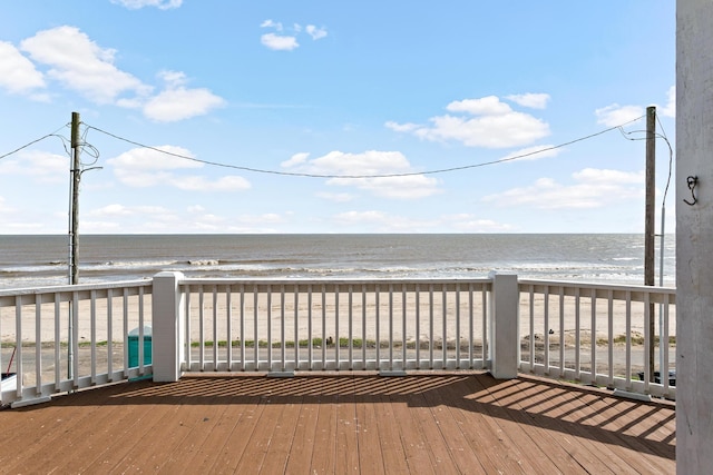 wooden deck with a water view and a view of the beach