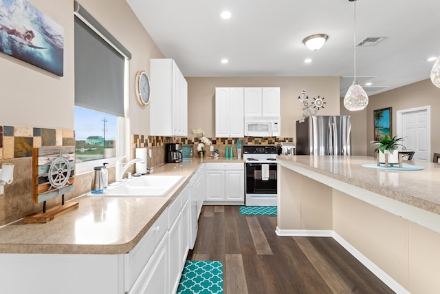 kitchen featuring white appliances, visible vents, a sink, light countertops, and backsplash