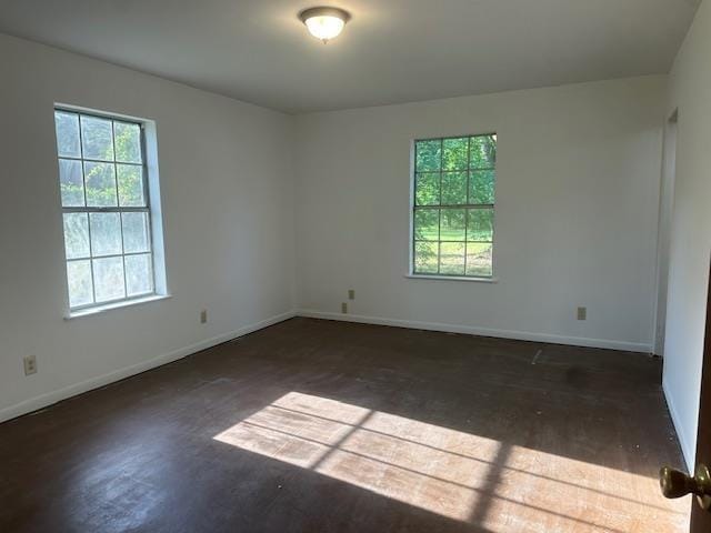 spare room featuring baseboards and wood finished floors
