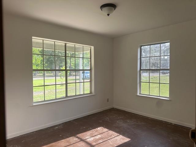 empty room featuring plenty of natural light and baseboards